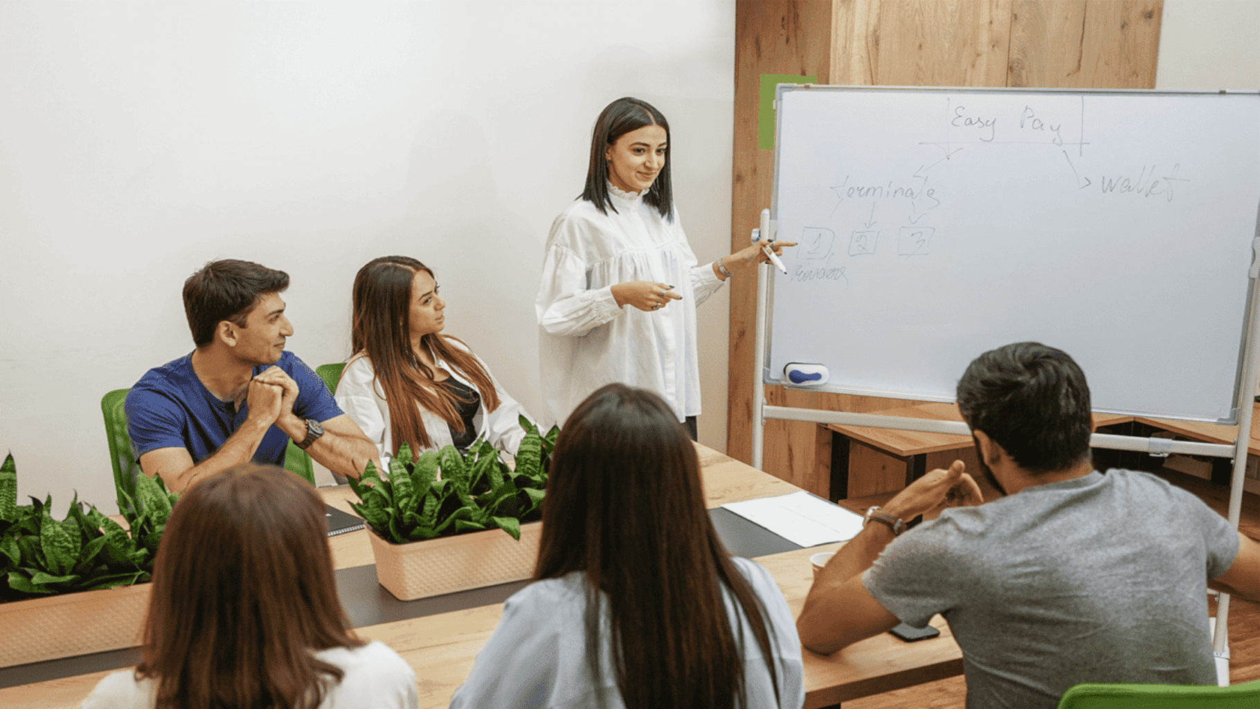 easypay worker standing in front of a whiteboard with people sitting around it