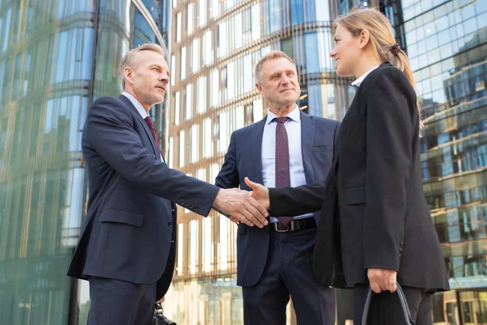 People shaking hands near the office, agreeing on business