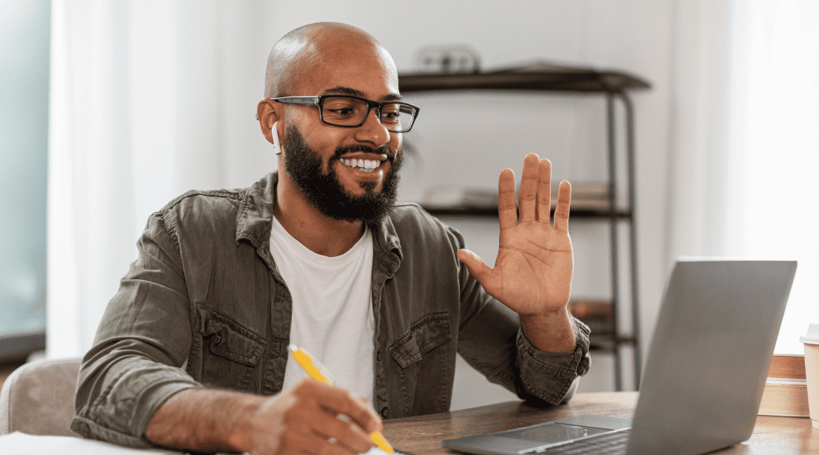 HR Manager Noting Points While Waving During their Online Session