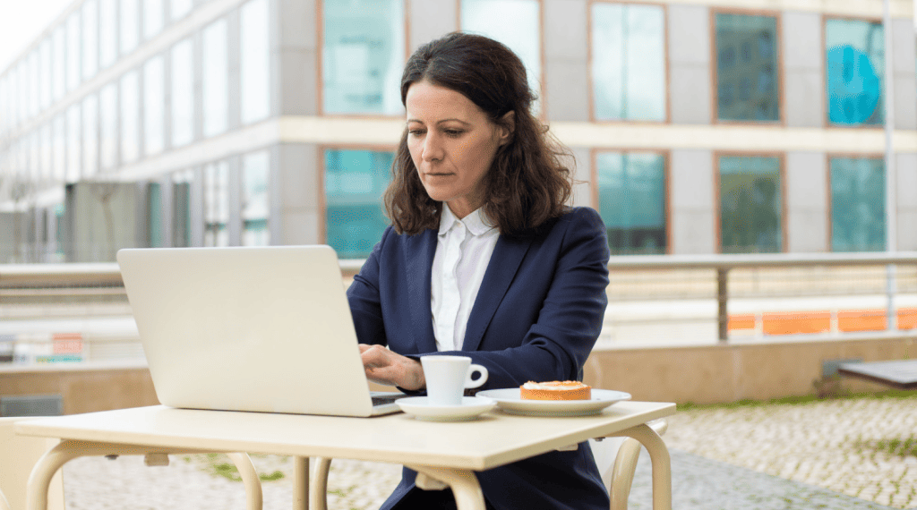 a woman sitting at a table with a laptop