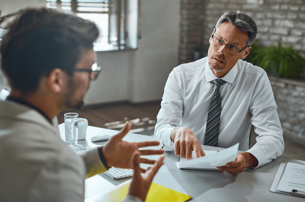 member-of-human-resource-team-talking-with-candidate-while-reviewing-his-resume-during-job-during-an-interview.